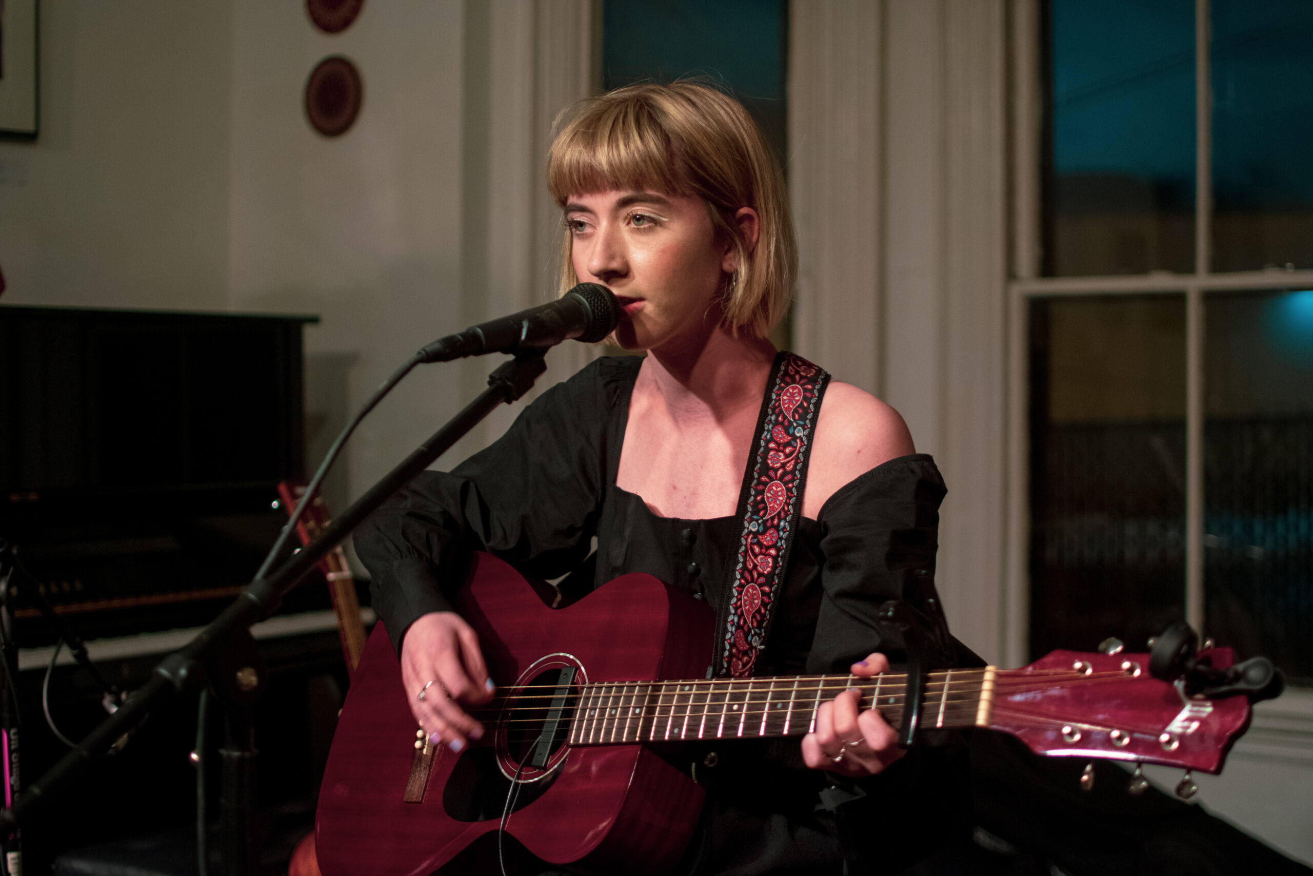 Solo artist Carol performing a headlining show to a crowd at an experimental folk showcase (2019)